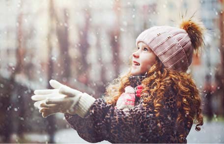 A young girl playing in the snow